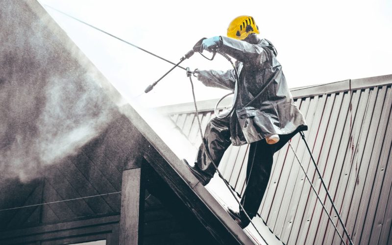 Technicien nettoyant une toiture pentue lors d'un entretien